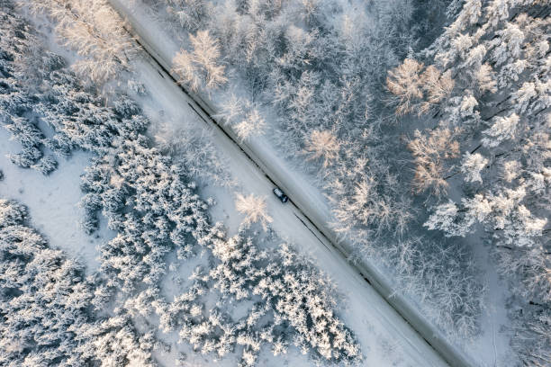istock Car moving on winter asphalt road, aerial top view 1410997723
