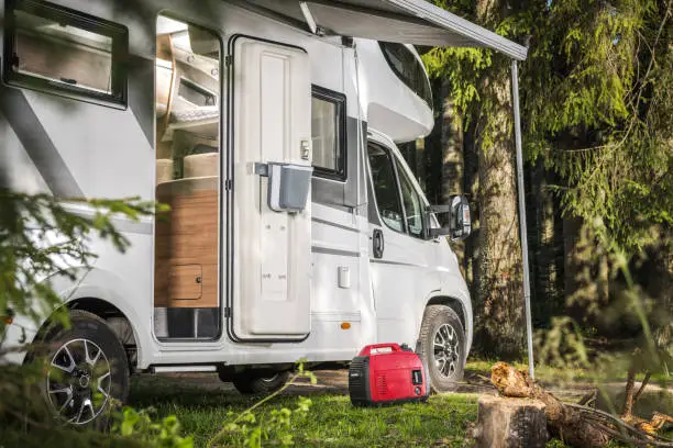 Recreational Vehicles Theme. Class C Camper Van RV and a Gas Generator Staying Next to the Motorhome. Summer Vacation.