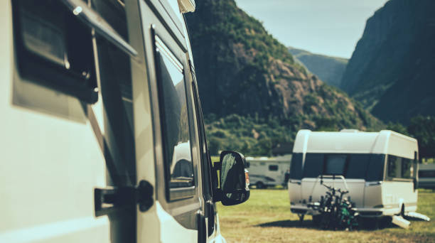istock Camper Van and A Travel Trailer in a Background Staying Inside a RV Park 1410997796