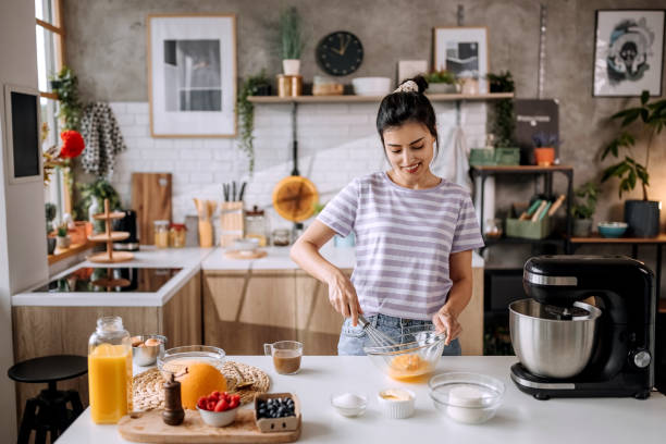 istock Young beautiful woman making a cake in her domestic kitchen 1410998078
