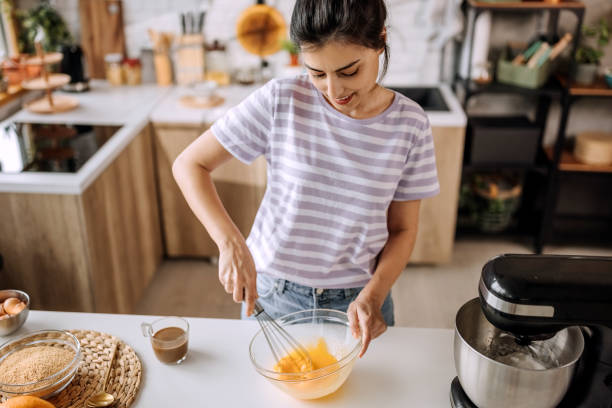 istock Young beautiful woman whisking eggs for a cake 1410998129