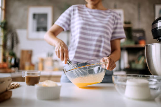 istock Young beautiful woman whisking eggs for a cake 1410998133