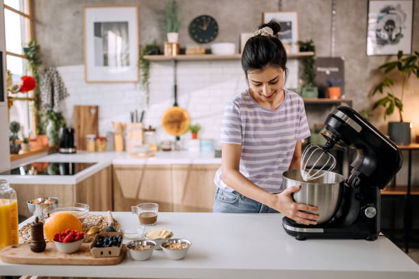istock Woman using electric table mixer in a domestic kitchen 1410998253