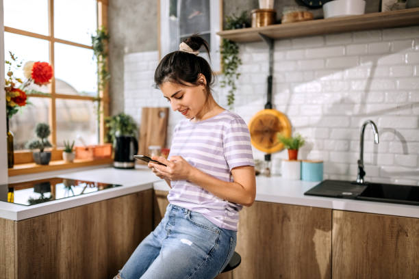 istock Beautiful young woman using a smart phone at home 1410998506