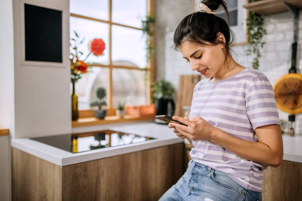istock Beautiful young woman using a smart phone at home 1410998537
