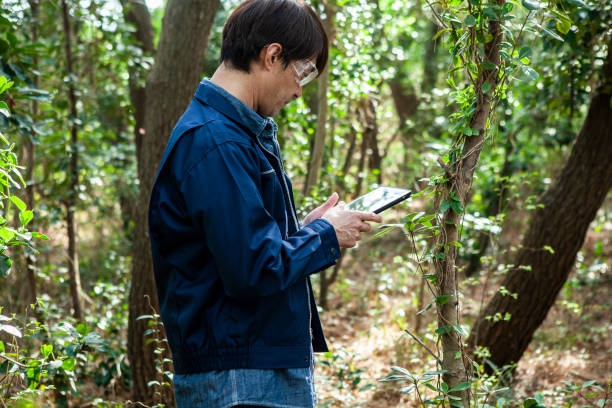 istock A man wearing protective glasses and work clothes is conducting an environmental survey with a tablet in his hand. 1410999431