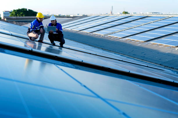 istock Specialist technician professional engineer with laptop and tablet maintenance checking installing solar roof panel on the factory rooftop under sunlight. Engineers team survey check solar panel roof. 1411000932