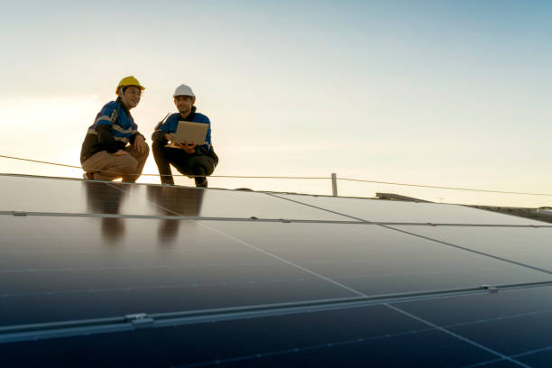 istock Specialist technician professional engineer with laptop and tablet maintenance checking installing solar roof panel on the factory rooftop under sunlight. Engineers team survey check solar panel roof. 1411000943