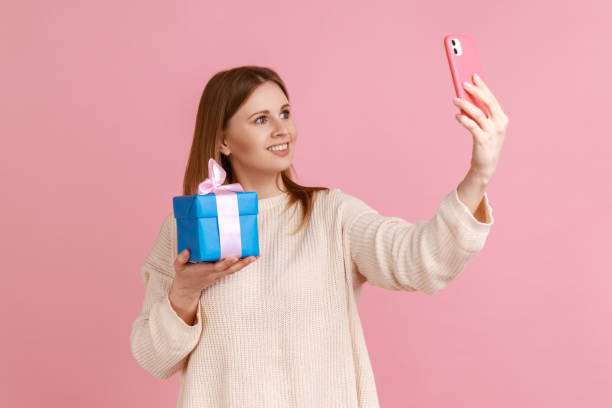 istock Woman taking selfie with her present or boasting her gift with followers while having livestream. 1411001806