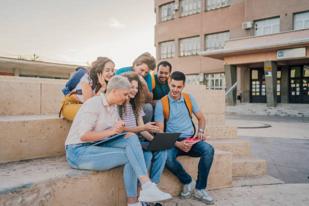 istock Group of students gathers around a laptop 1411002142