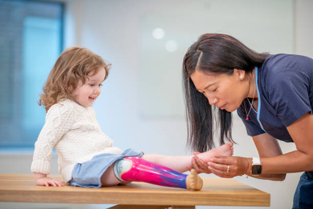 bambina con gamba protesica all'appuntamento medico - male nurse immagine foto e immagini stock