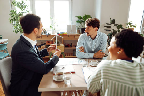 istock Engineers having a discussion about windmills in the office 1411003649