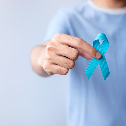 Mes azul de concientización sobre el cáncer de próstata en noviembre, hombre con camisa azul con la mano sosteniendo la cinta azul para apoyar la vida y la enfermedad de las personas. Salud, Hombres internacionales, Padre, Diabetes y Día Mundial del C� photo