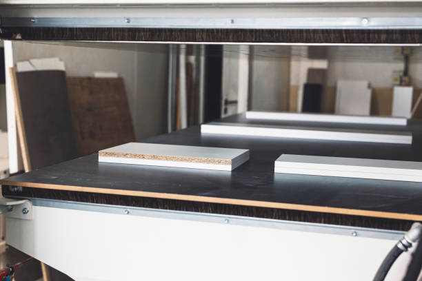 White furniture boards on a black desk in the furniture manufacturing company.