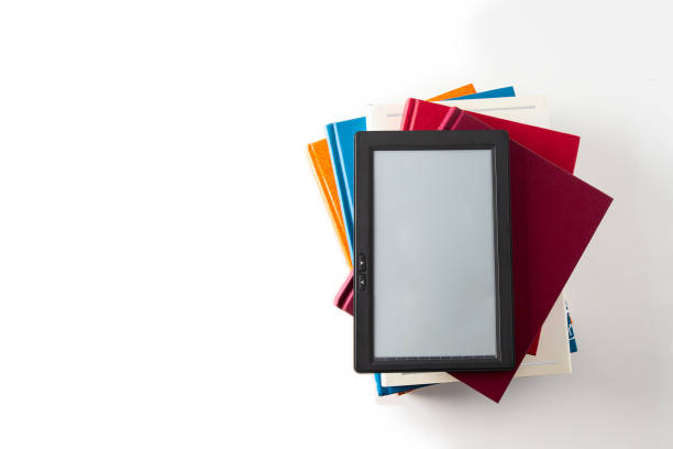 Top view  of E-book reader on the stack of traditional books on white background. Concept for modern reading.Copy space