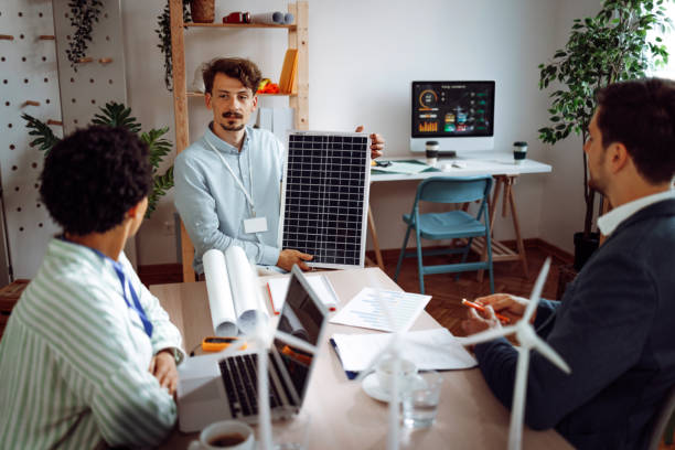 istock Young businessman talking about solar panel with his colleagues in the office 1411004666