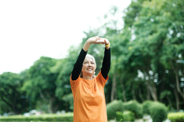 istock Athletic Senior woman stretching arms in park. 1411005666
