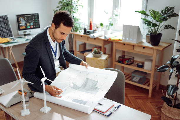 istock Young handsome architect planning his work in the office 1411006624