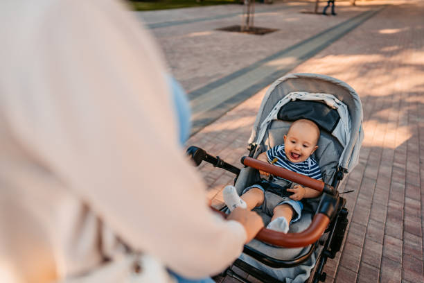 istock Young Mother Having A Walk Through The Park With Her Baby 1411007478