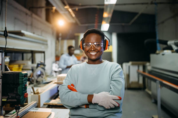 istock Young female professional carpenter posing with protective wear equipped 1411009609