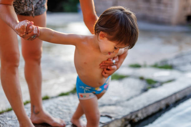 Mother holding baby boy by the pool