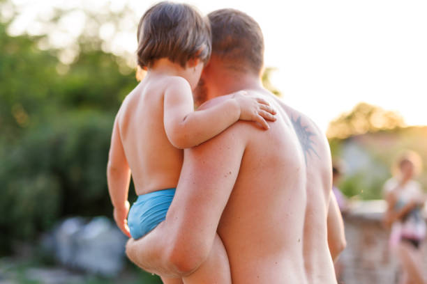 Fathers holds his son during summer vacation
