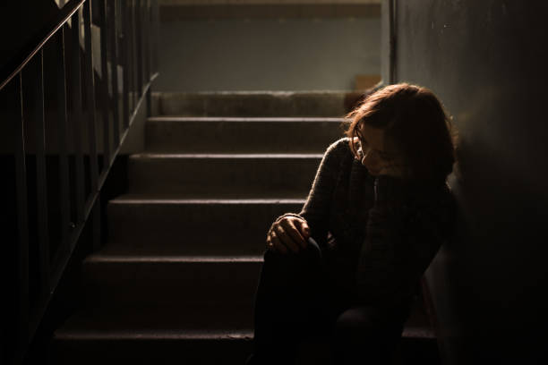 woman in a dark sweater at the steps, concept of loneliness and depression, selective focus, dark style, abstraction