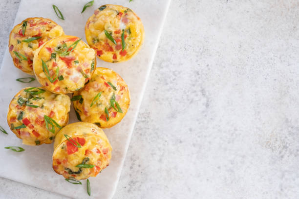 яичные кексы с ветчиной, сыром и овощами - omelet breakfast eggs onion стоковые фото и изображения