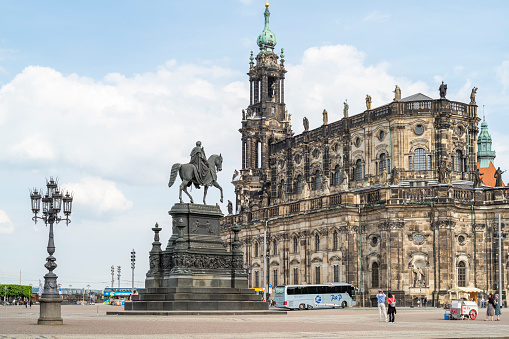 Dresden, Germany - May 10, 2022: The historic Catholic Hofkirche in Dresden by day. In front of it is the König-Johann-Monument.