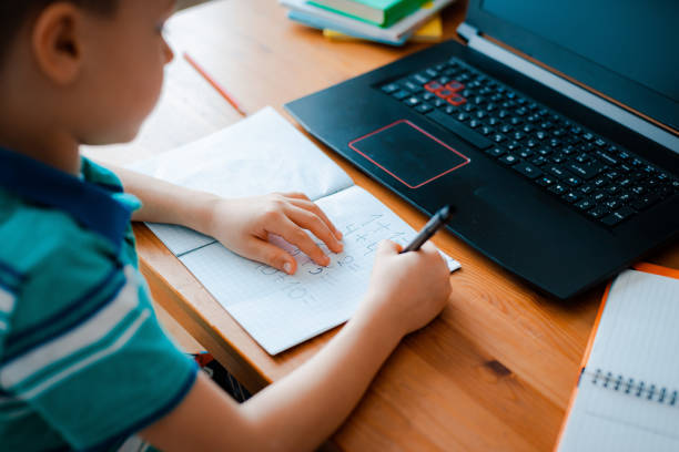 istock Distance learning online education. A schoolboy boy studies at home and does school homework. A home distance learning 1411013426