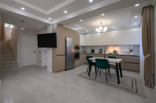 istock Modern white and beige large luxurious kitchen and dining table in studio apartment 1411013540