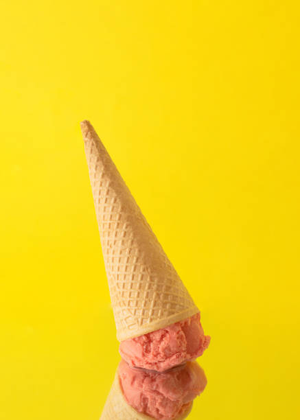 istock Ice cream cone with pink, peachy ball standing upside down on a mirror. 1411014013