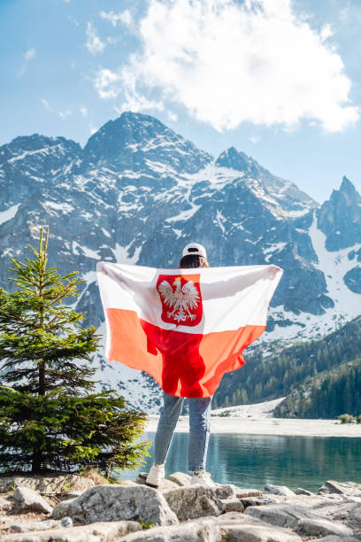 폴란드 국기를 든 한 여성이 호수 기슭에 서 있다. 모르스키 오코 - tatra mountains zakopane lake mountain 뉴스 사진 이미지