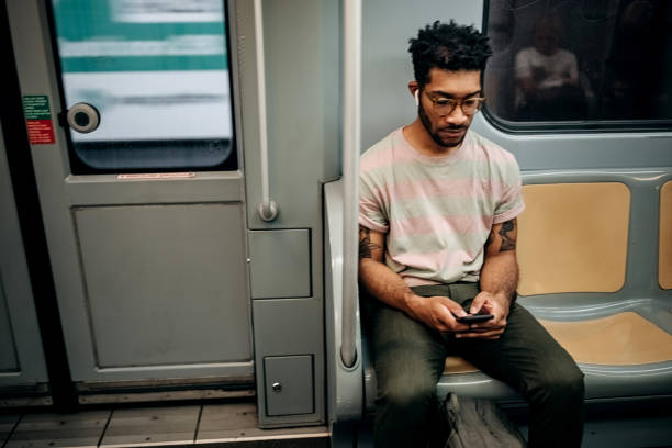 istock Casually clothed man texting while riding in the metro 1411015079