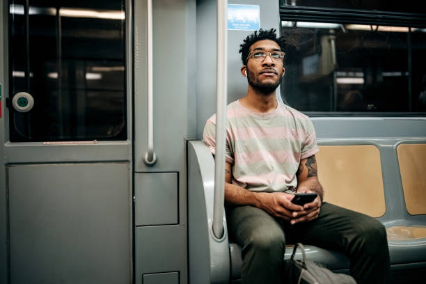 Casually clothed man texting while riding in the metro