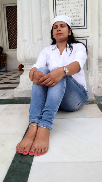 istock Young woman meditating in Gurudwara, Amritsar, Punjab, India 1411016078