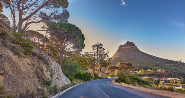 an empty road on the mountain at sunrise. street overlooking mountain peak with a scenic view of the city from a street on the mountain at sunset. the landscape of a beautiful view of lions head - sunrise city of sunrise street road imagens e fotografias de stock