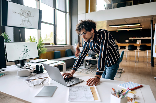 Character game developer working in the office on a laptop