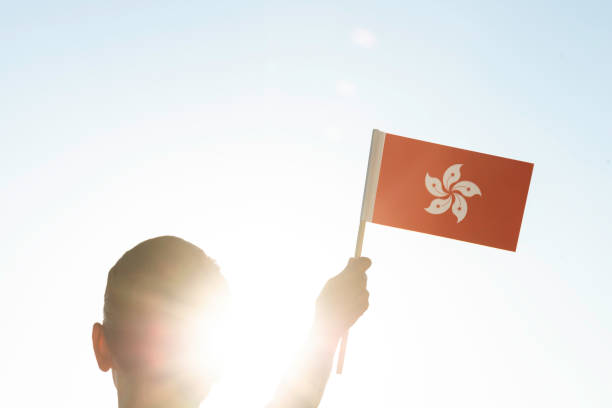 Back view unrecognizable female holding Hong Kong flag in hand.