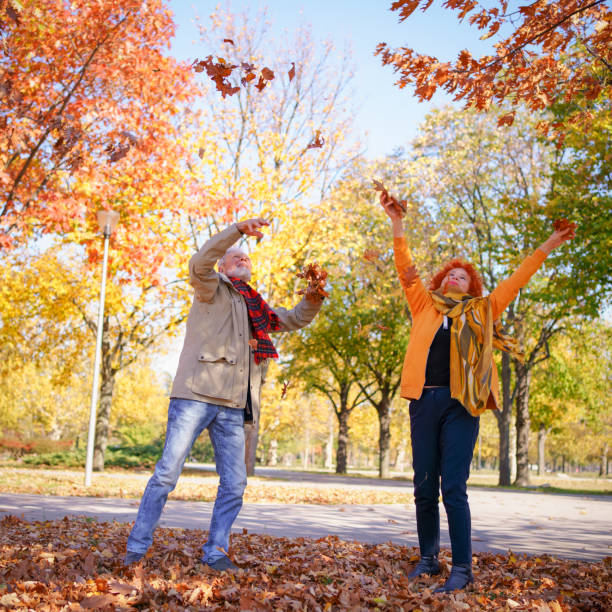 istock Senior couple throwing leaves around 1411021894