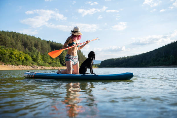 istock Woman riding paddle board with her dog. 1411022110