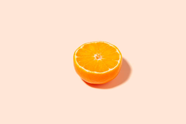 istock A bright slice of ripe orange on a peach background. 1411022171