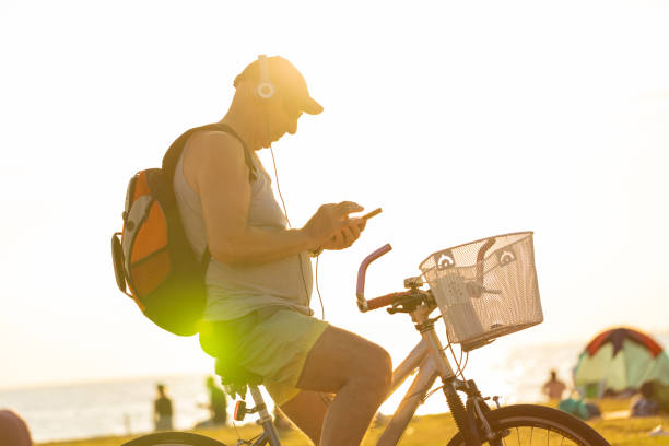 istock Profile of senior active man on a bike using phone 1411025070