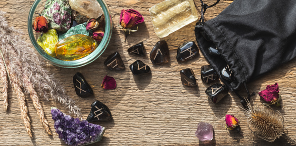 Natural minerals and rune stones set up on wood. Magical ritual process, future telling concept