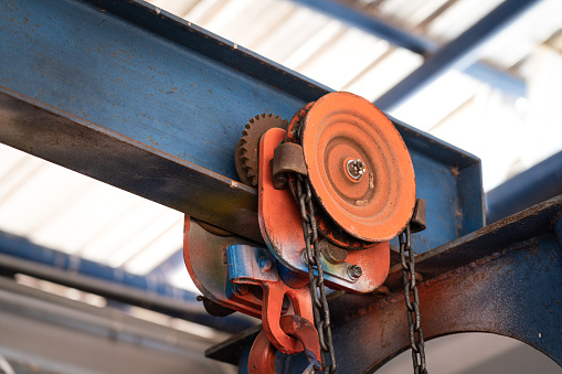 Close-up at hoisting reel which is installed on the structure beam at the factory. Industrial equipment object photo.