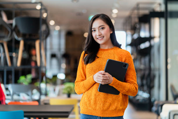 istock asian female smart entrepreneur walk working use tablet device stock manage and checking product inventory in furniture showroom,asian woman smiling cheerful business owner work in furniture store 1411026452