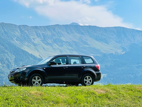 Vals, Switzerland - July, 22nd - 2022: Subaru SUV standing on a meadow, mountains in background