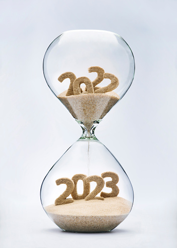New Year 2023 concept with hourglass falling sand taking the shape of a 2023
