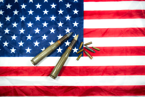 American flag with bullets, shells, cartridges and projectiles on it. Lend-Lease concept.  Army concept. Sales of weapons and ammunition. Military industry, war, global arms trade.