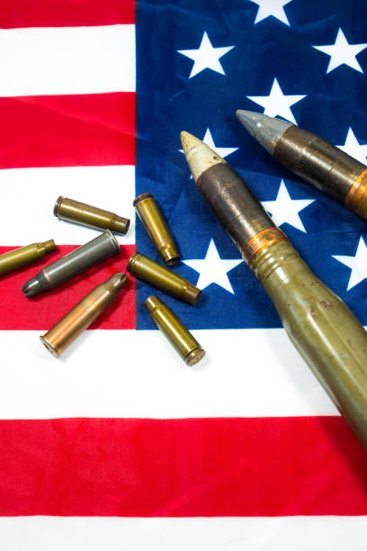 istock American flag with bullets, shells, cartridges and projectiles on it. Lend-Lease concept.  Army concept. Sales of weapons and ammunition. Military industry, war, global arms trade. 1411030320